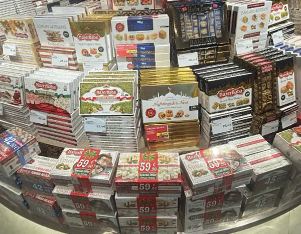 Display of assorted boxed Turkish delights, baklava, and sweets at a travel retail store.
