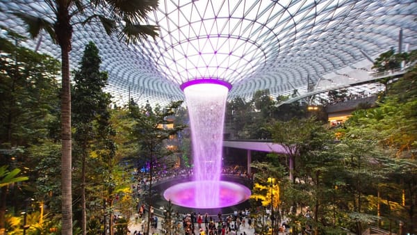 Indoor waterfall surrounded by lush greenery under a giant glass dome at Jewel Changi Airport, Singapore — the world’s tallest indoor waterfall, known as the Rain Vortex.
